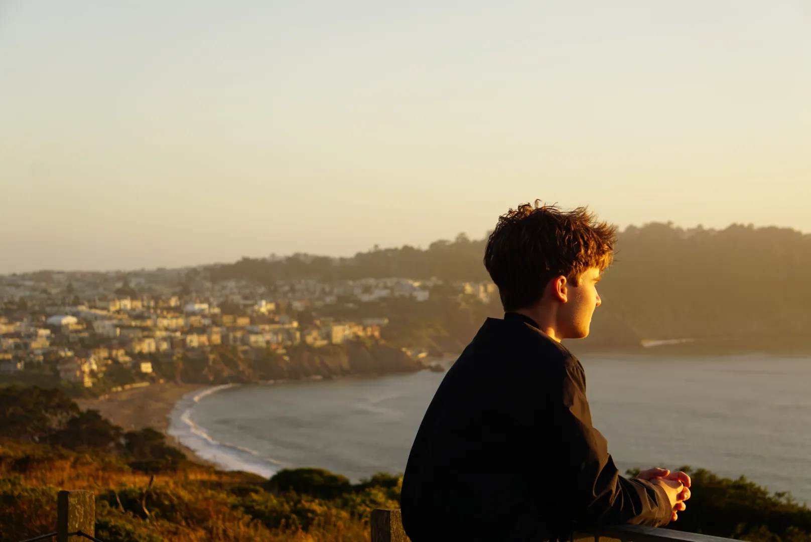 Jacob Webster looking out over the coastline at sunset